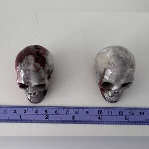 2 carved stone skulls